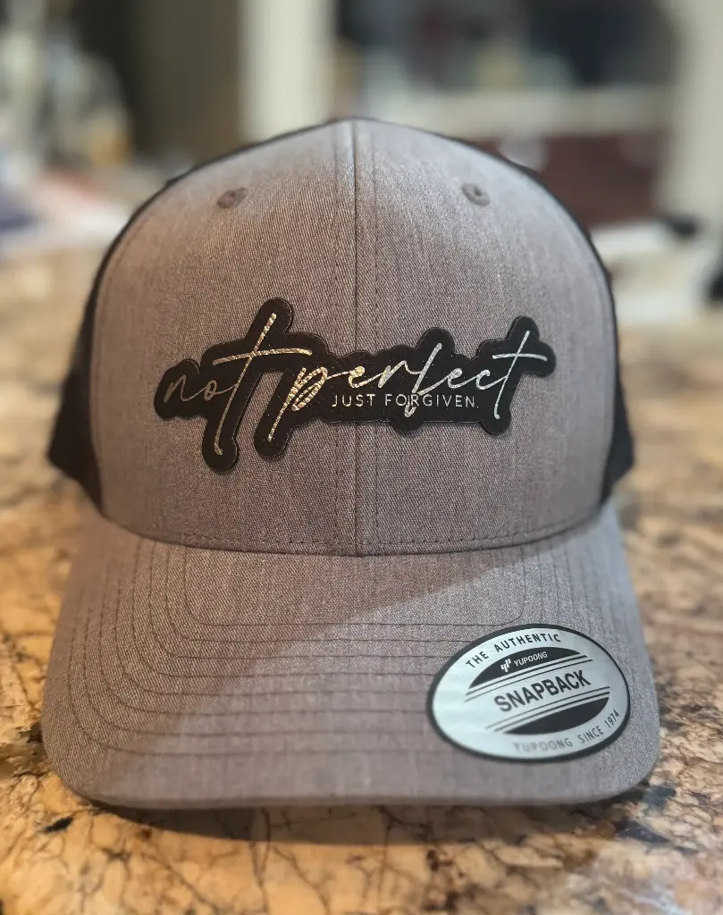 "Not Perfect, Just Forgiven” Trucker Hat – Gray & Black 5-Panel (Black with Silver Engraving)